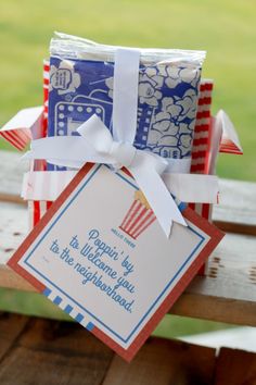 some folded up cards sitting on top of a wooden bench with a ribbon around it