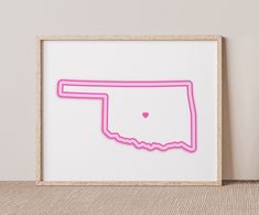 a pink framed paper cut out of the shape of a heart on top of a map