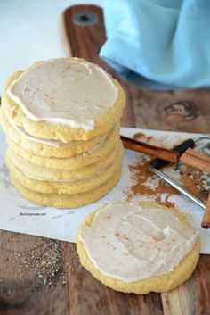 a stack of cookies sitting on top of a wooden cutting board next to a knife