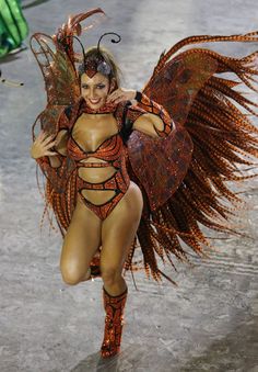 a woman in a costume is walking down the runway with wings on her head and body