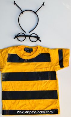 a yellow and black striped shirt with glasses on it's head next to a pair of eyeglasses