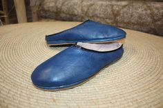 "Comfortable leather slippers. Open shapes for easy putting on. Warm fur interior. Exterior Leather Blue Jeans. Made entirely by hand. Charentaise type sewing \"returned sewn\" method.  - 100% Solid  - 100% Comfort  - 100% Sustainable Available from 35 to 45. Put on easily and effortlessly. Non-slip soles. Use indoors or outdoors, your choice of shoes or slippers! Tanning of 100% Natural colored leather based on water and minerals without chemicals. The leather will become more and more supple over time, for unparalleled comfort, you won't be able to take them off! For our future customers not used to real craftsmanship, traces of glue, small defects or irregularities are possible, your slippers will be all the more unique!" Comfortable Blue Leather Clogs, Comfortable Blue Slippers With Rubber Sole, Blue Slip-on Slippers With Rubber Sole, Blue Leather Slippers With Round Toe, Blue Leather Mules With Leather Sole, Blue Leather Sole Slip-on Mules, Blue Slip-on Slippers With Round Toe, Blue Slip-on Mules With Leather Sole, Blue Leather Closed Toe Slippers