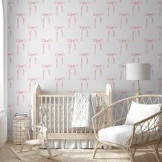 a baby's room with pink bows on the wall and white crib bedding