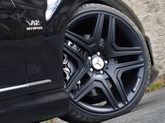 the front wheel of a black mercedes car