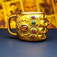 a gold mug with different colored stones on it