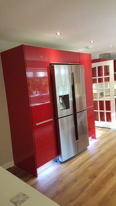 a kitchen with red cabinets and stainless steel refrigerator