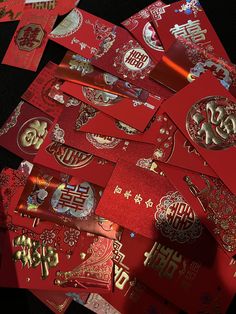 a pile of red envelopes with chinese writing on them, all covered in gold foil