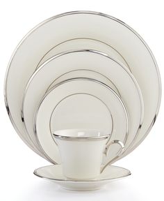 a white dinner set with silver trimmings