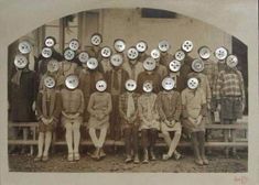 a group of people standing next to each other in front of a building with buttons on their faces