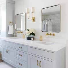 a white bathroom with two sinks and mirrors