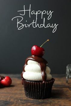 a cupcake with chocolate frosting and a cherry on top that says happy birthday