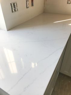 a white counter top in a kitchen next to cabinets