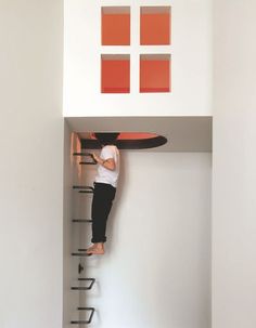 a man standing on top of a ladder next to a surfboard in a room