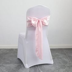 a white chair with a pink bow tied to it's back on a tile floor