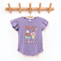 Looking for a cute tee for your daughter? We have the perfect flutter sleeve graphic tee. Purple Cartoon Print Tops For Spring, Playful Purple Tops With Cartoon Print, Cute Purple Top With Letter Print, Cute Purple Top With Graphic Print, Cute Purple Spring T-shirt, Cute Lavender Cotton Top, Playful Purple Short Sleeve Tops, Cool Ice Cream, Top Graphic Tees