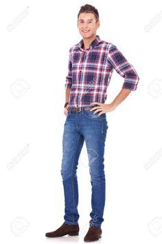 a young man standing with his hands in his pockets and smiling at the camera stock photo