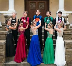 a group of young people standing next to each other in front of a door wearing costumes