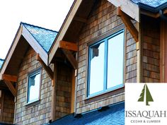 the side of a house with wood shingles and windows on top of each other