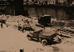 an old black and white photo of men working on the construction of a bridge over water