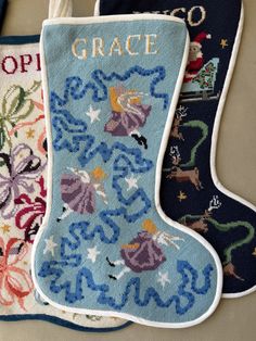 three stocking designs are hanging on the wall next to each other, including one with an ornament that says grace