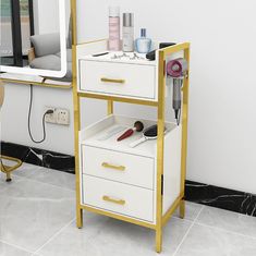 a white and gold shelf with hair products on it in front of a vanity mirror