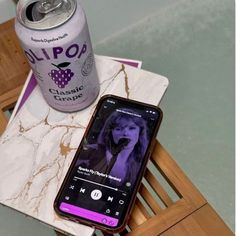 a cell phone sitting on top of a table next to a can of soda