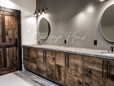 a bathroom with two sinks and mirrors on the wall next to a wooden door that says boutique plans