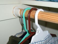 three toothbrushes are hanging from a wooden rack