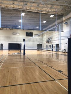 an indoor gym with hard wood floors and basketball hoops on the sidelines for people to play volleyball