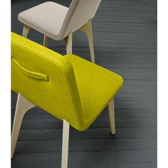 two chairs sitting on top of a wooden floor next to each other in different colors