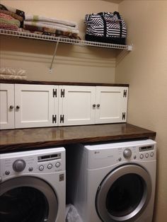 a washer and dryer sitting next to each other in a room with white cabinets