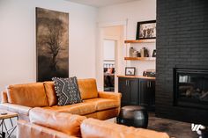 a living room with two couches and a fireplace in the corner on one side