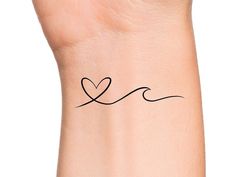 a small wrist tattoo with a heart on it