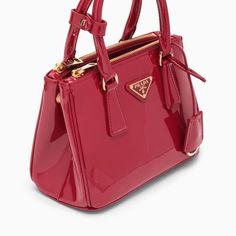 Mini Galleria handbag from Prada in cherry-coloured patent leather, featuring two top handles, snap fasteners on the sides, two zipped compartments, an interior zipped pocket, an adjustable and removable shoulder strap, a removable logoed key ring and gold-coloured metal hardware. Width 24 cm x Height 18 cm x Depth 11 cm Adjustable shoulder strap length min 116 cm - max 126 cm Handle drop: 10 cm Size Type: INTMaterial: LeatherSKU: 1BA906EOM069/O_PRADA-F0E06_100 Our Products Are 100% Genuine. In Red Leather Bags With Glossy Finish, Elegant Red Bag With Glossy Finish, Chic Red Bag With Glossy Finish, Patent Leather Bag With Detachable Top Handle, Everyday Patent Leather Bag With Detachable Handle, Patent Leather Bag With Detachable Handle For Everyday Use, Designer Patent Leather Bag With Glossy Finish, Glossy Patent Leather Top Handle Bag, Top Handle Bags With Glossy Finish For Shopping