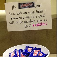 a white bowl filled with candy next to a sign