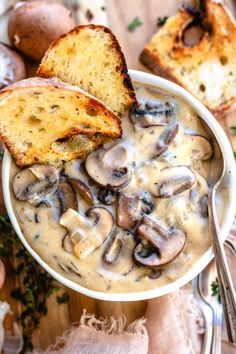 a bowl of mushroom soup with bread on the side