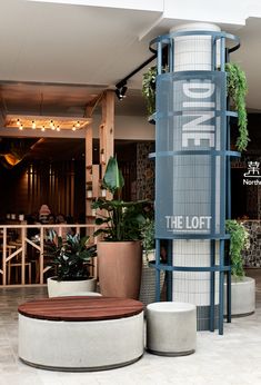 there is a sign that says one the loft next to some potted plants in front of it