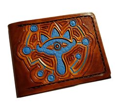 a brown leather wallet with an eye on the front and blue details in the middle