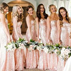 a group of women standing next to each other in long pink dresses and holding bouquets