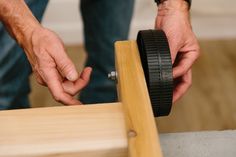 a man is working on a piece of wood with a circular sawtoothing tool