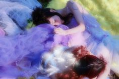 two women laying on top of each other in colorful dresses and tulle skirtes