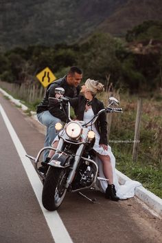 a man and woman are sitting on a motorcycle