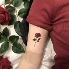 a woman with a rose tattoo on her arm