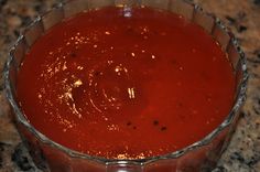 a glass bowl filled with red liquid on top of a counter