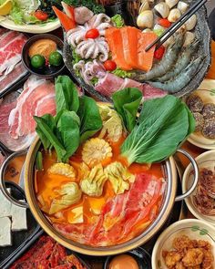 a table topped with lots of different types of food and bowls filled with meats