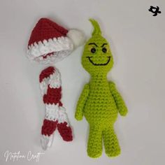 two crocheted toys are sitting next to each other on a white surface, one is green and the other is red