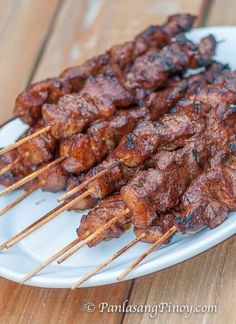 several skewers of meat on a white plate