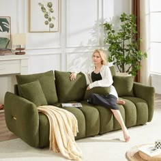 a woman sitting on top of a green couch