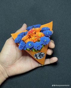 a hand holding an origami flower bouquet