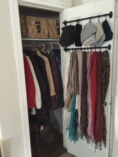 an open closet with clothes hanging on hooks